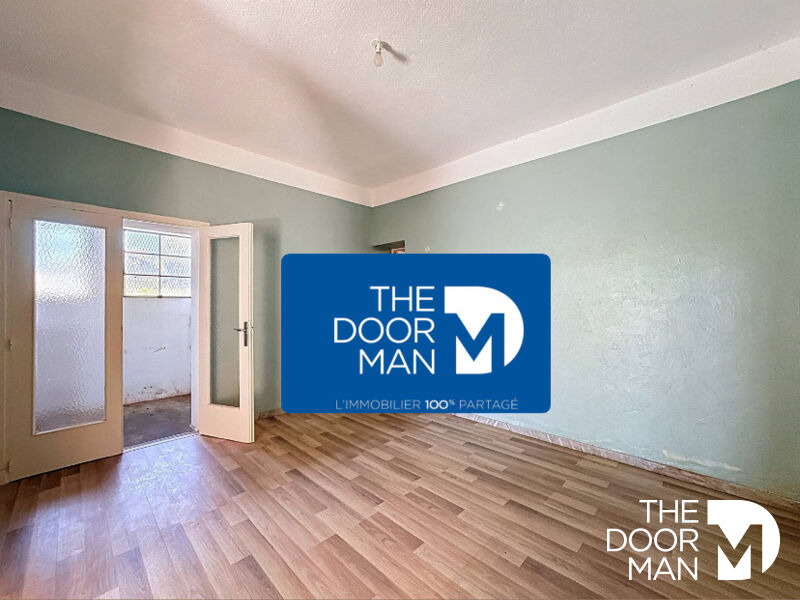 Appartement à vendre au Lavandou Intérieur d'un appartement à vendre dans un immeuble au Lavandou, avec murs peints en vert et sol en parquet.