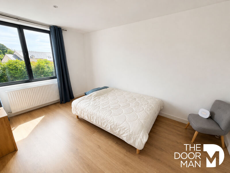 Spacious room with a single bed and a window overlooking a garden.