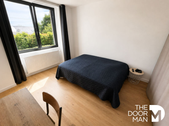 Room in a house in Matignon with a bed and a window overlooking the outside.