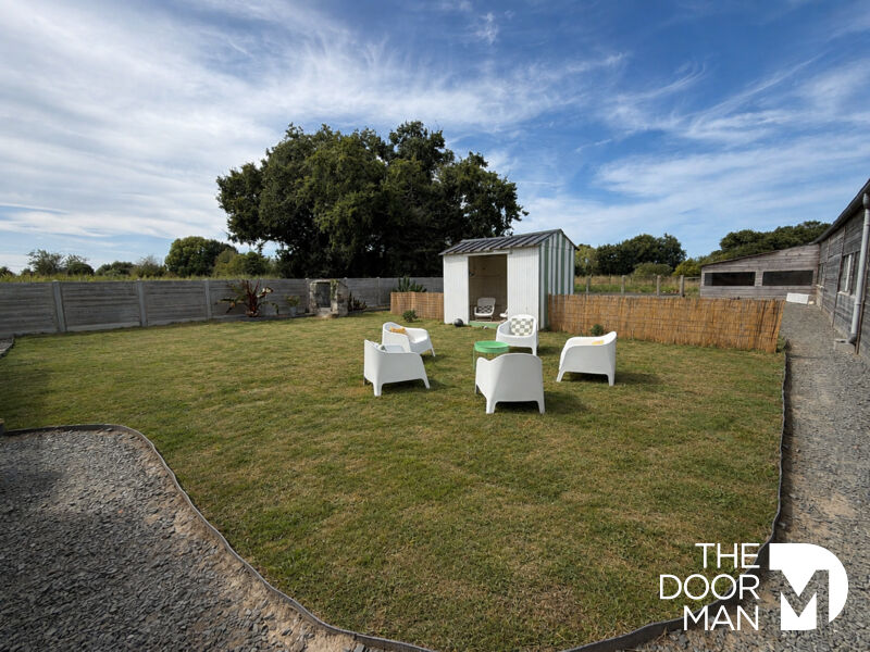 Garden with white chairs and garden shed in a property in Matignon.