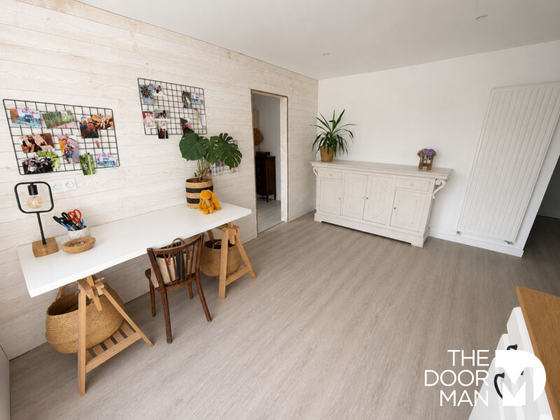 Interior of a house with a desk, chairs and plants.