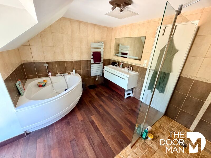 spacious bathroom Modern bathroom with bathtub and shower, tiled walls and parquet flooring.