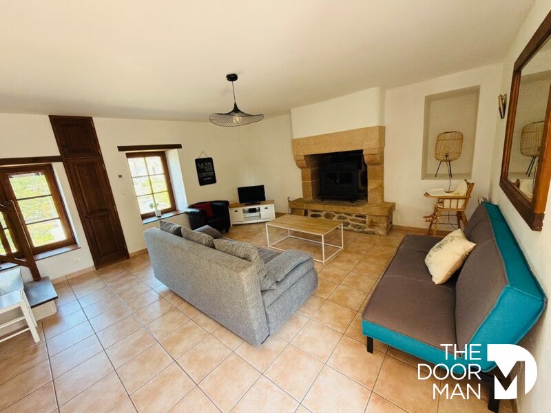 Interior of a longhouse in Aucaleuc Interior of a stone farmhouse with living room, fireplace and modern furniture.