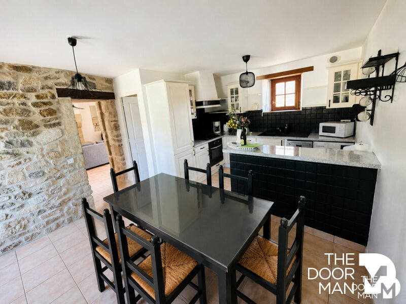 Kitchen of a longhouse in Aucaleuc Kitchen of a stone farmhouse with table and chairs, exposed stone walls, in Aucaleuc.
