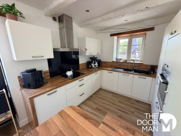 Modern kitchen with wooden furniture and appliances.