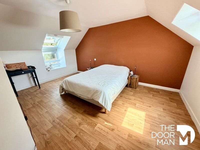 Room in a longhouse in Aucaleuc Room in a stone farmhouse in Aucaleuc with orange walls and wooden parquet flooring.