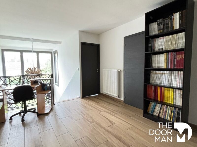 Interior of a contemporary house Interior of a contemporary house with desk and shelving, wooden floor, bright windows.