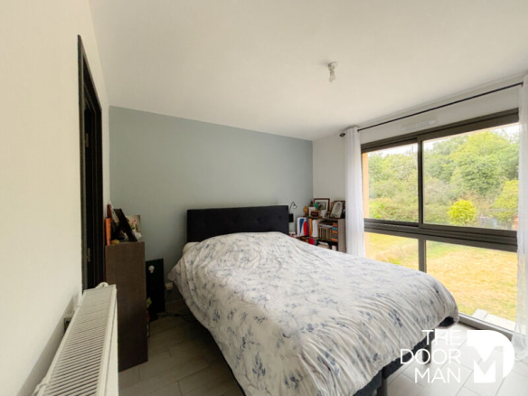 Bedroom in a contemporary house with a window overlooking a garden.