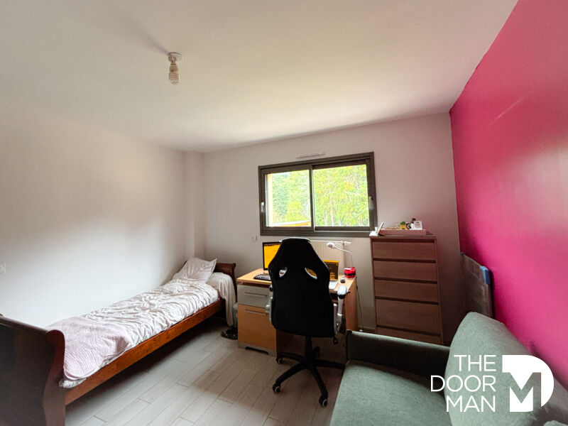 Room in a contemporary house Bedroom in a contemporary house with a single bed, a desk and a sofa.