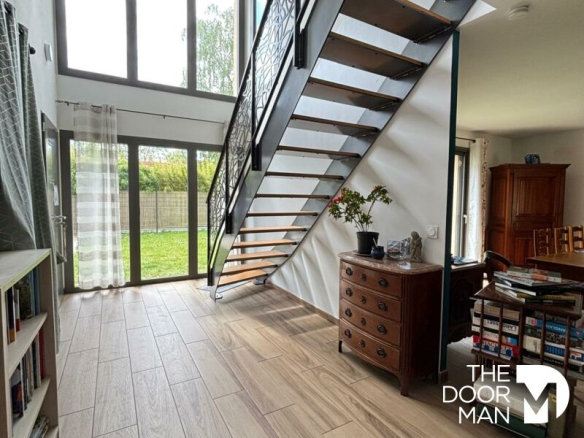 Interior of a contemporary house with a modern staircase and a large living room.