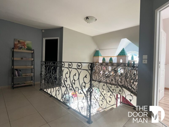 Interior of a house in Limours with a wrought iron balcony and natural lighting.
