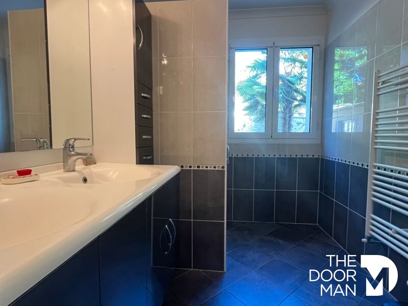 Bathroom in the house in Limours Modern bathroom with sink and window, grey and white tiles.