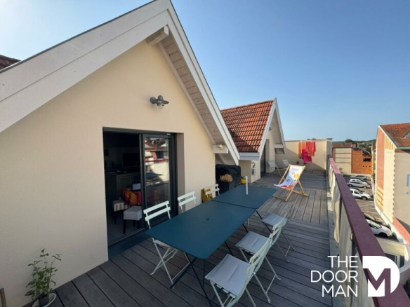 Terrace of a duplex in Arcachon with outdoor furniture and unobstructed view.