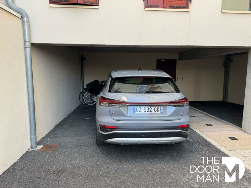 Car parked under cover in Arcachon Car parked under a shelter in a residence in Arcachon, with a bicycle next to it.
