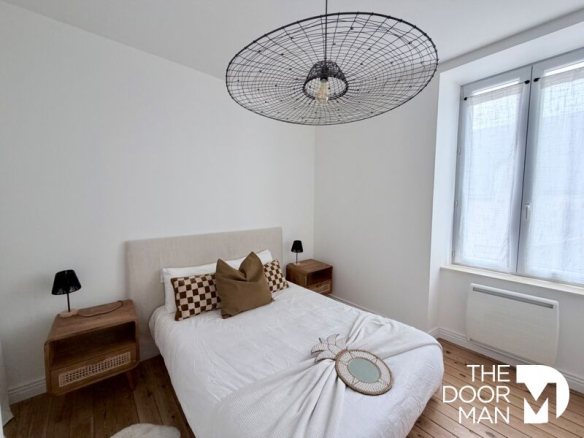 Room in a house in Le Pouliguen, with bed, bedside lamps and modern decor.