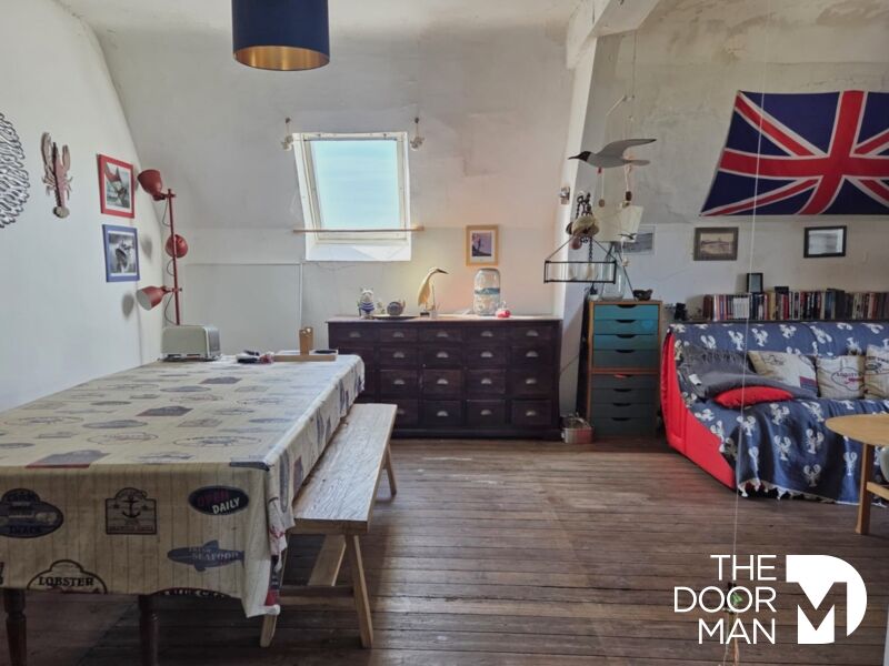 Intérieur d’un appartement à Mesquer Intérieur d'un appartement avec une table à manger, un canapé et des décorations murales.