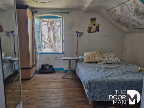 Chambre d'appartement avec lit, miroir et fenêtre donnant sur l'extérieur.