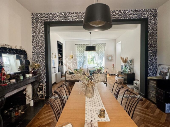 Intérieur d'une maison de ville à Laval avec une grande table et un salon lumineux.