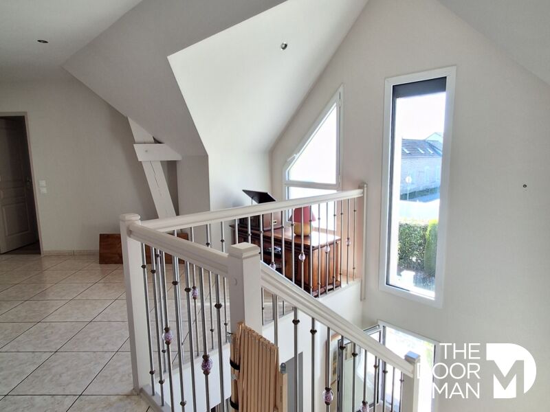 Intérieur d’une maison familiale Intérieur d'une maison moderne avec un escalier et des fenêtres lumineuses.
