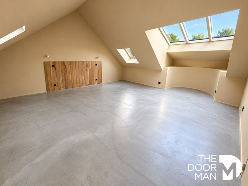 Intérieur d'une propriété rénovée avec des murs clairs et un sol en béton poli.