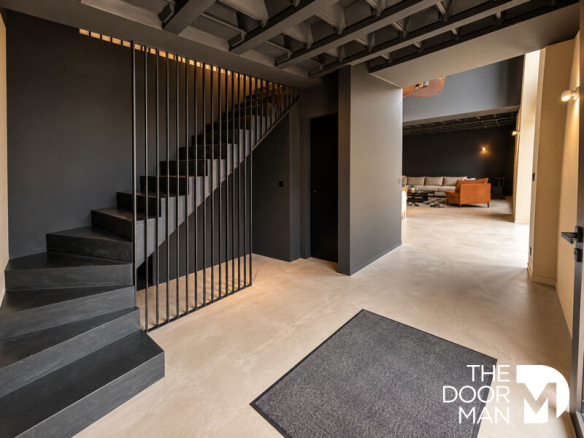Intérieur d'une propriété moderne à Saint-Malo avec un escalier design et un espace de vie ouvert.