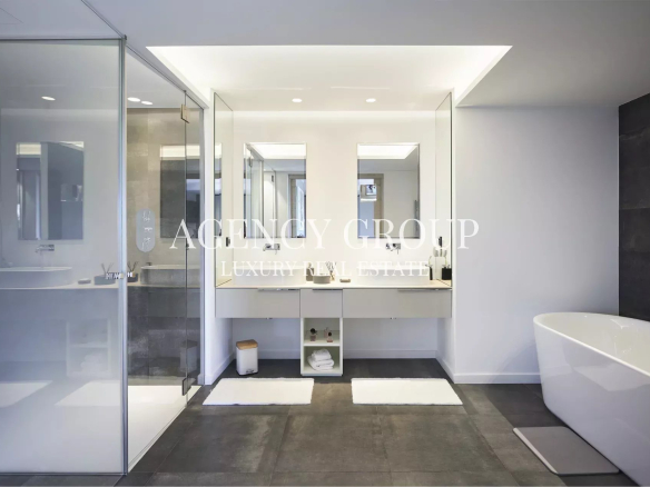 Modern, luxurious bathroom with a glass-enclosed shower, double vanity, and a freestanding oval tub in a white-gray color palette.