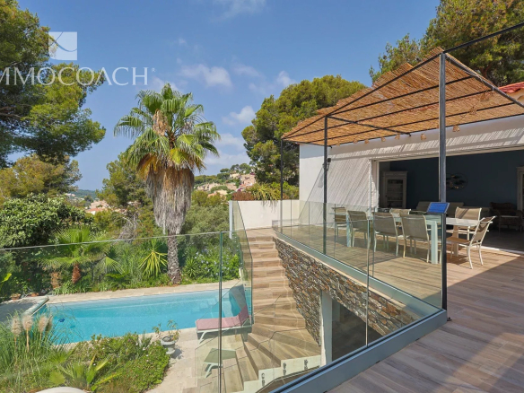 Maison rénovée à Carqueiranne avec piscine et terrasse, entourée de verdure.