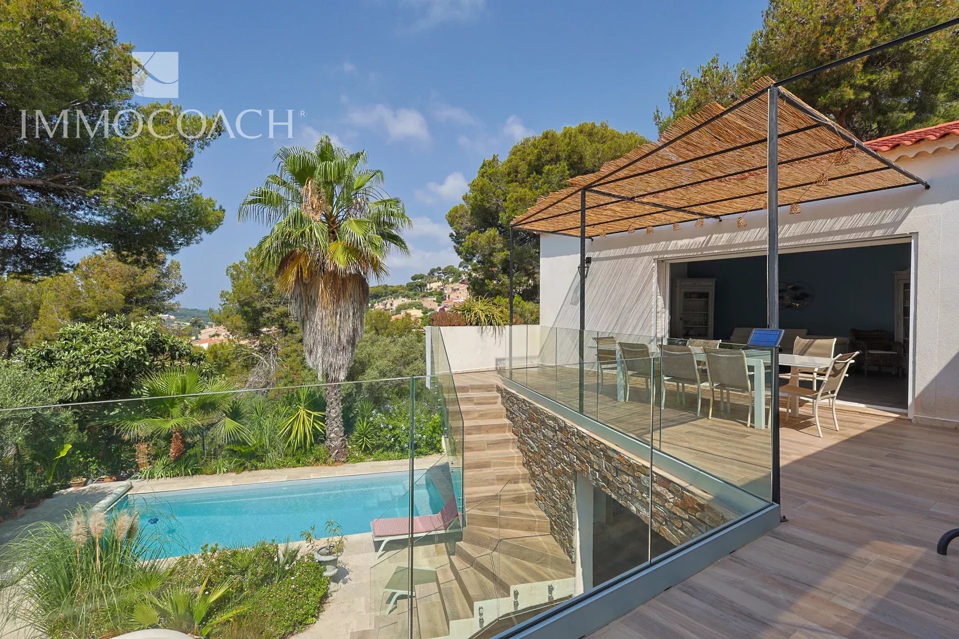 Maison rénovée à Carqueiranne avec piscine et terrasse, entourée de verdure.