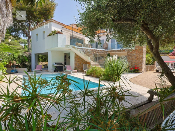 Maison rénovée avec piscine et jardin à Carqueiranne, entourée de verdure.