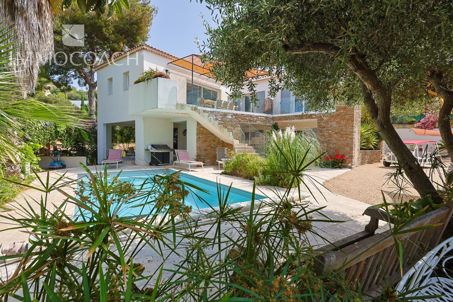 Maison rénovée avec piscine et jardin à Carqueiranne, entourée de verdure.