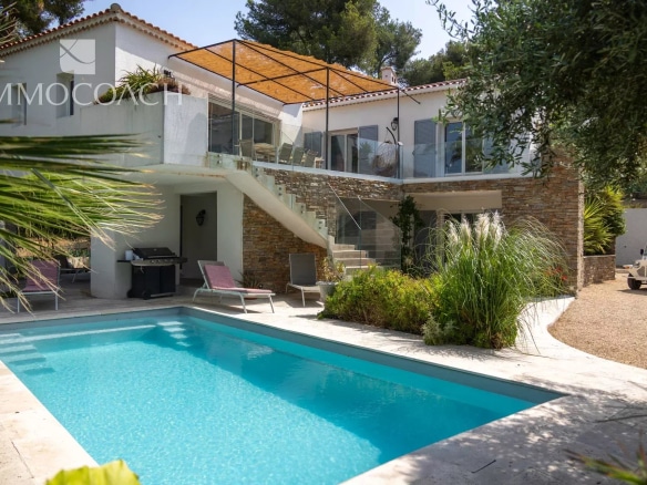 Maison rénovée avec piscine et terrasse à Carqueiranne, entourée de verdure.