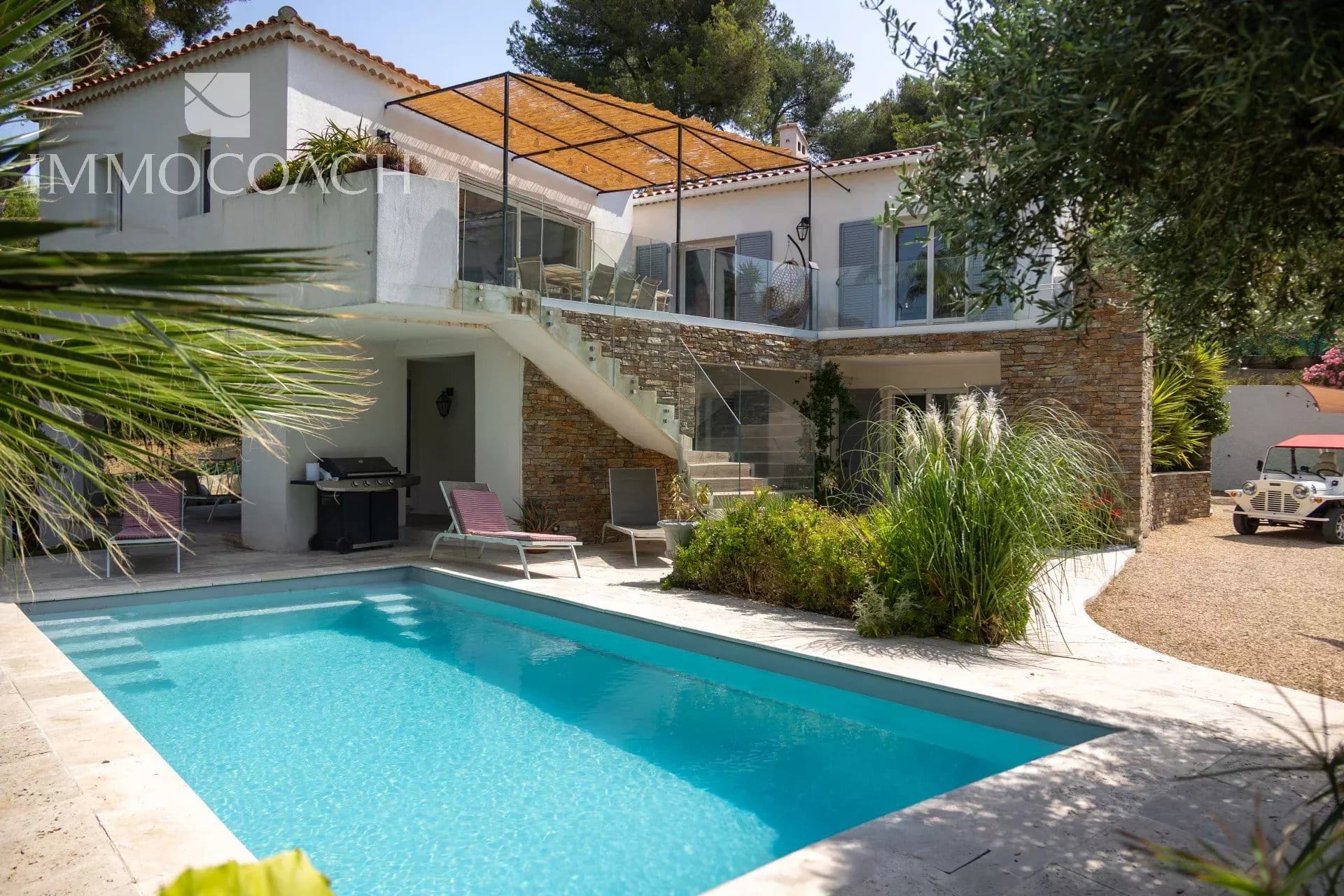 Maison rénovée avec piscine et terrasse à Carqueiranne, entourée de verdure.