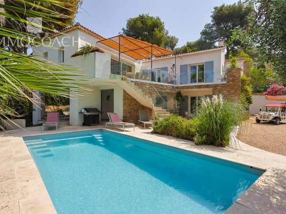 Maison rénovée avec piscine à Carqueiranne, entourée de verdure et de terrasse.