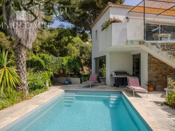Maison rénovée avec piscine et jardin à Carqueiranne, entourée de verdure.