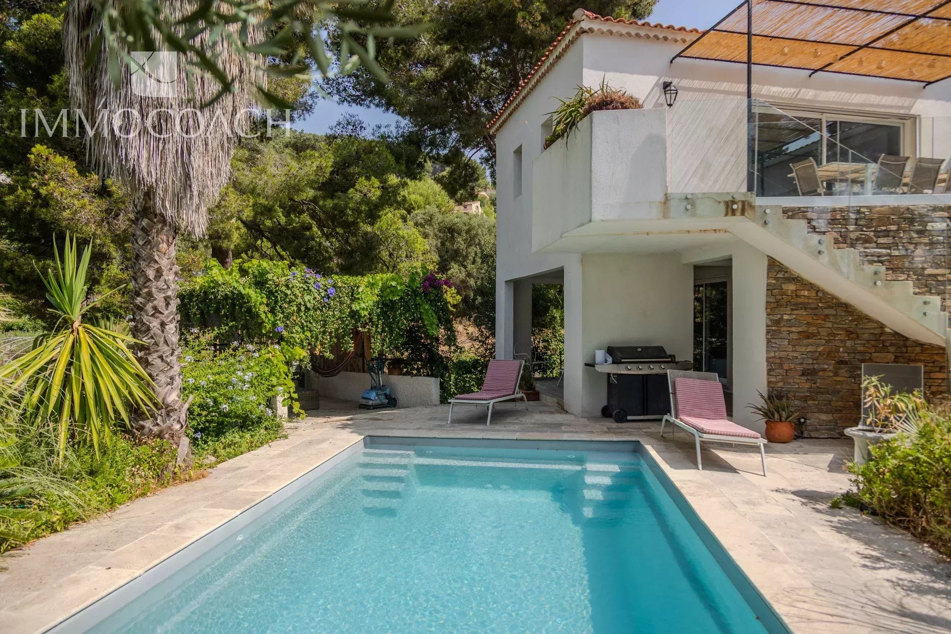 Maison rénovée avec piscine et jardin à Carqueiranne, entourée de verdure.
