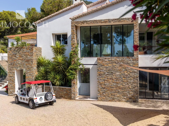 Maison rénovée à Carqueiranne avec façade en pierre et véhicule électrique devant.
