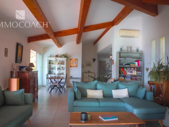 Intérieur d'une villa contemporaine à Hyères avec salon lumineux et cuisine ouverte.