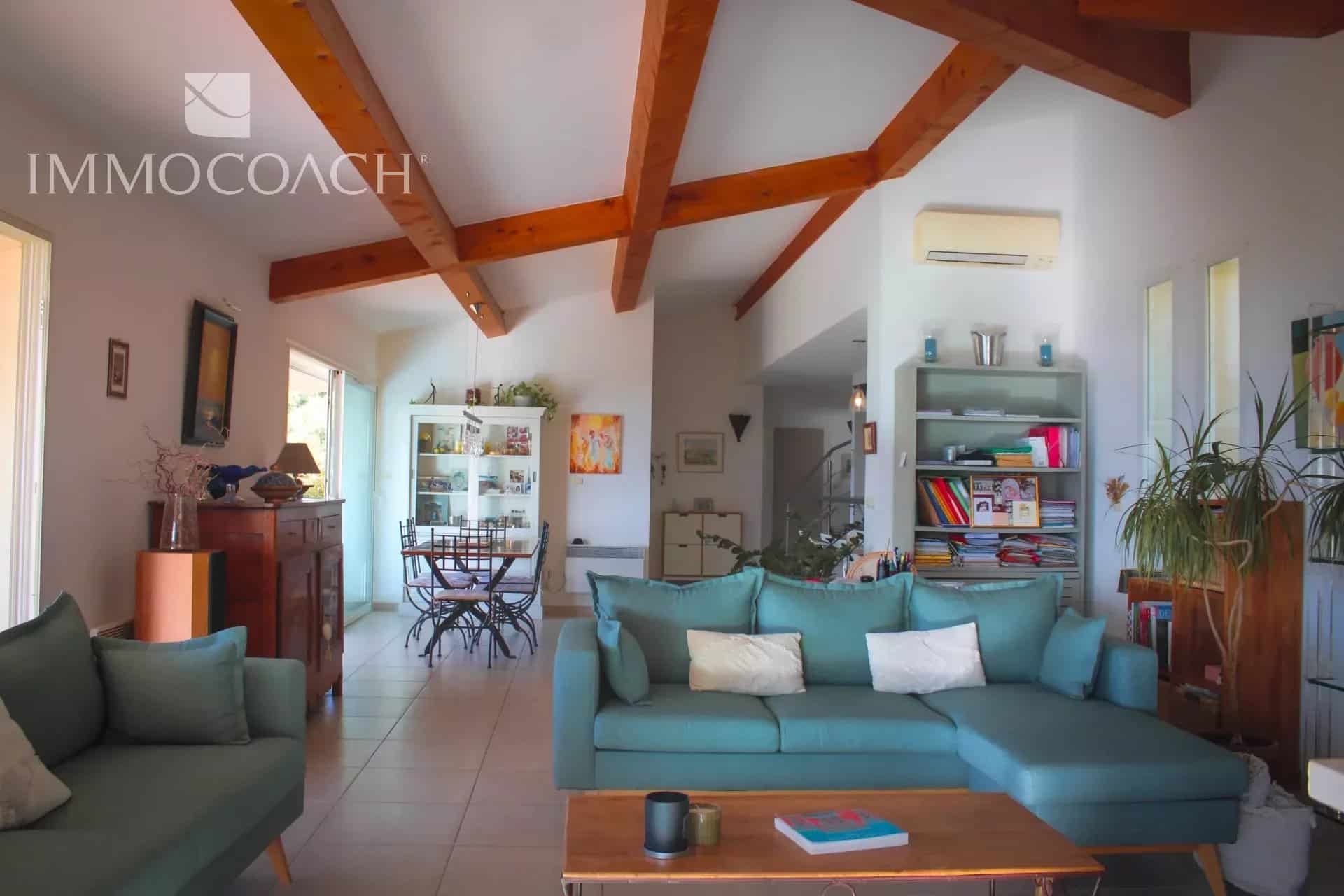 Intérieur d'une villa contemporaine à Hyères avec salon lumineux et cuisine ouverte.