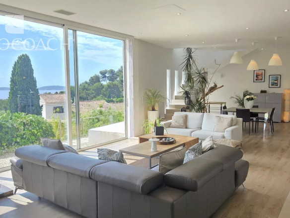 Intérieur d'une maison contemporaine avec vue sur la mer, salon spacieux et lumineux.