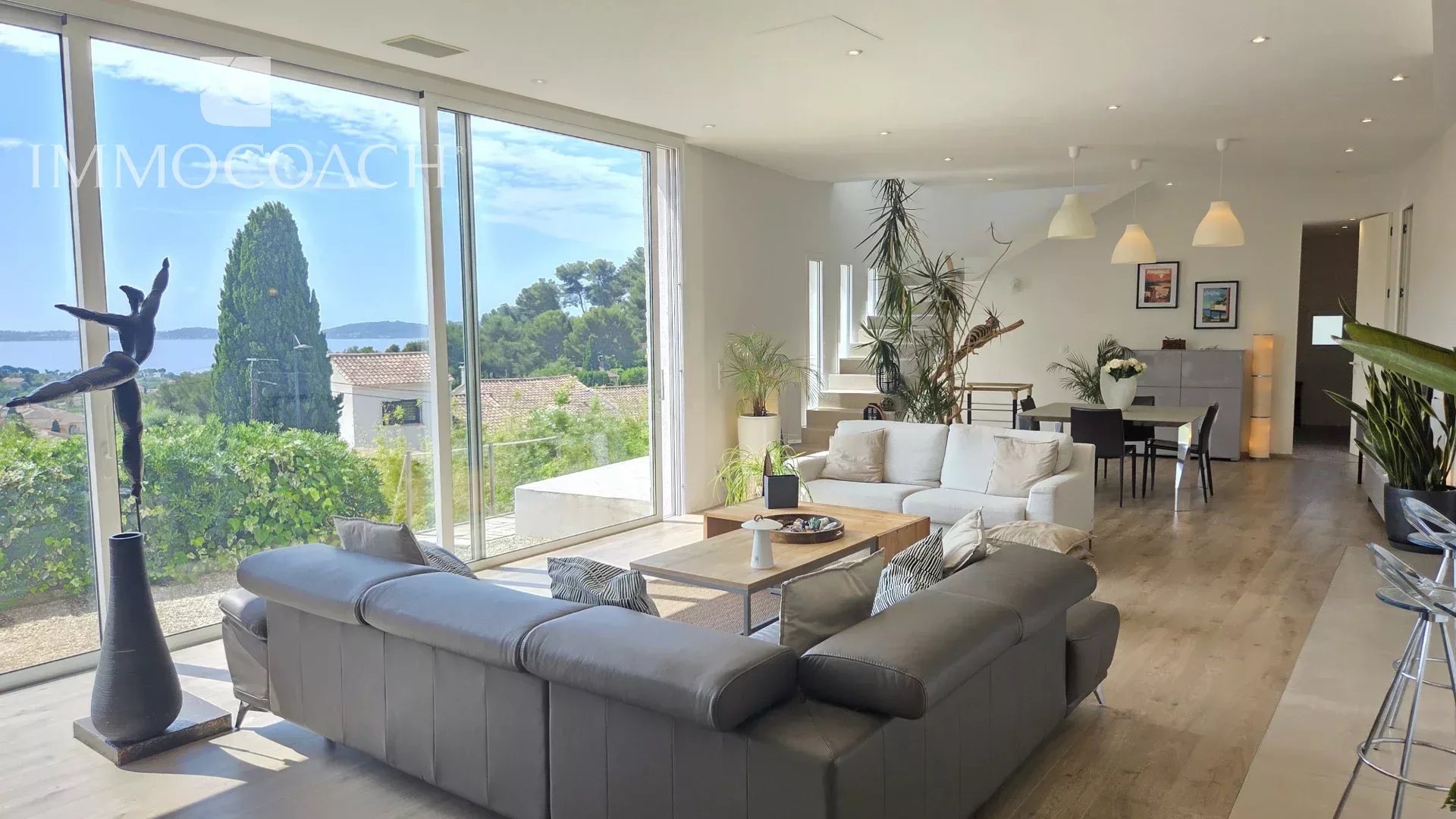 Intérieur d'une maison contemporaine avec vue sur la mer, salon spacieux et lumineux.