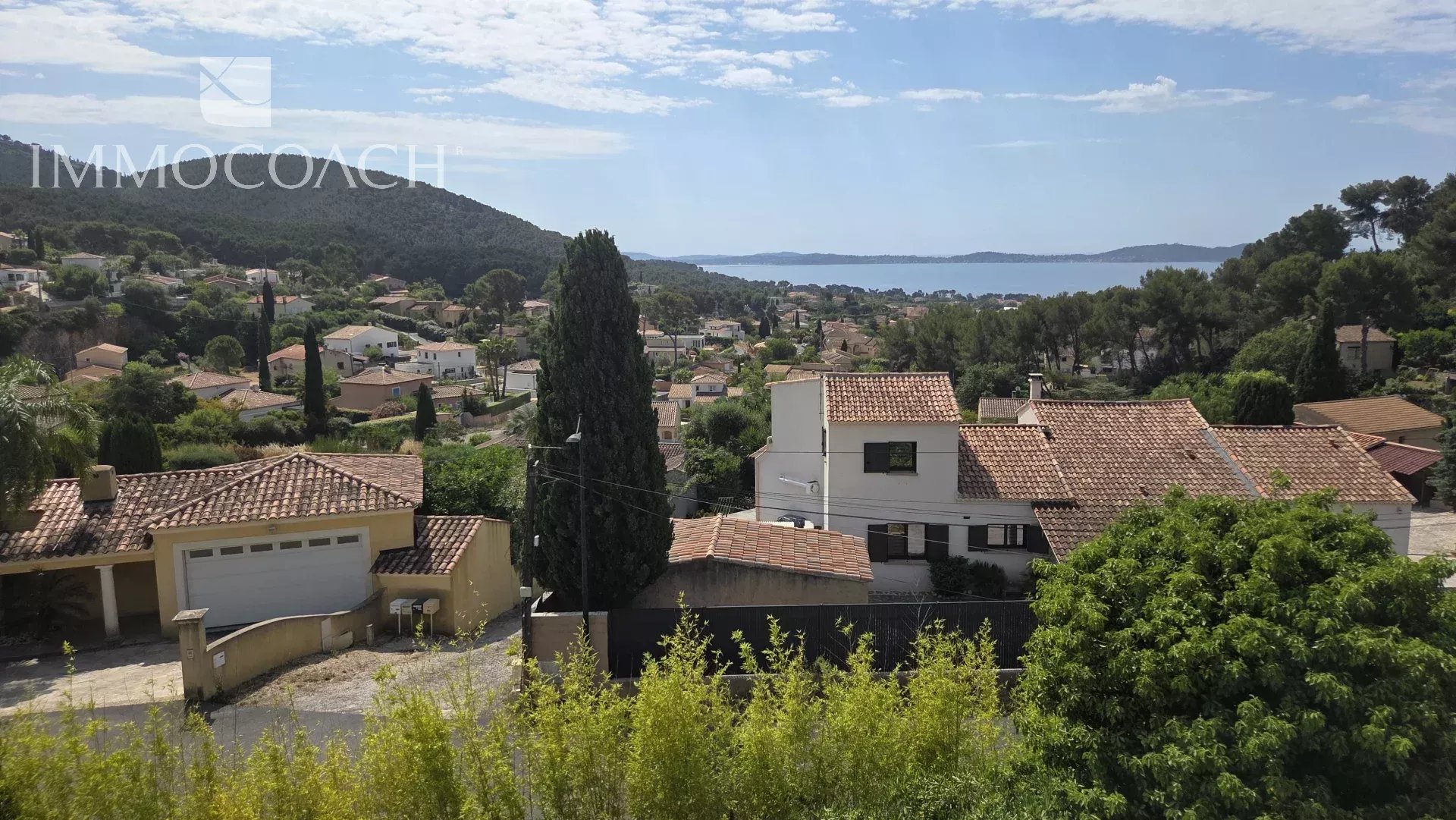 Vue panoramique d'une maison contemporaine à Carqueiranne avec vue sur la mer et les collines environnantes.