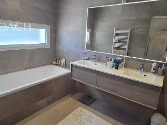 Salle de bain moderne avec baignoire et double vasque.