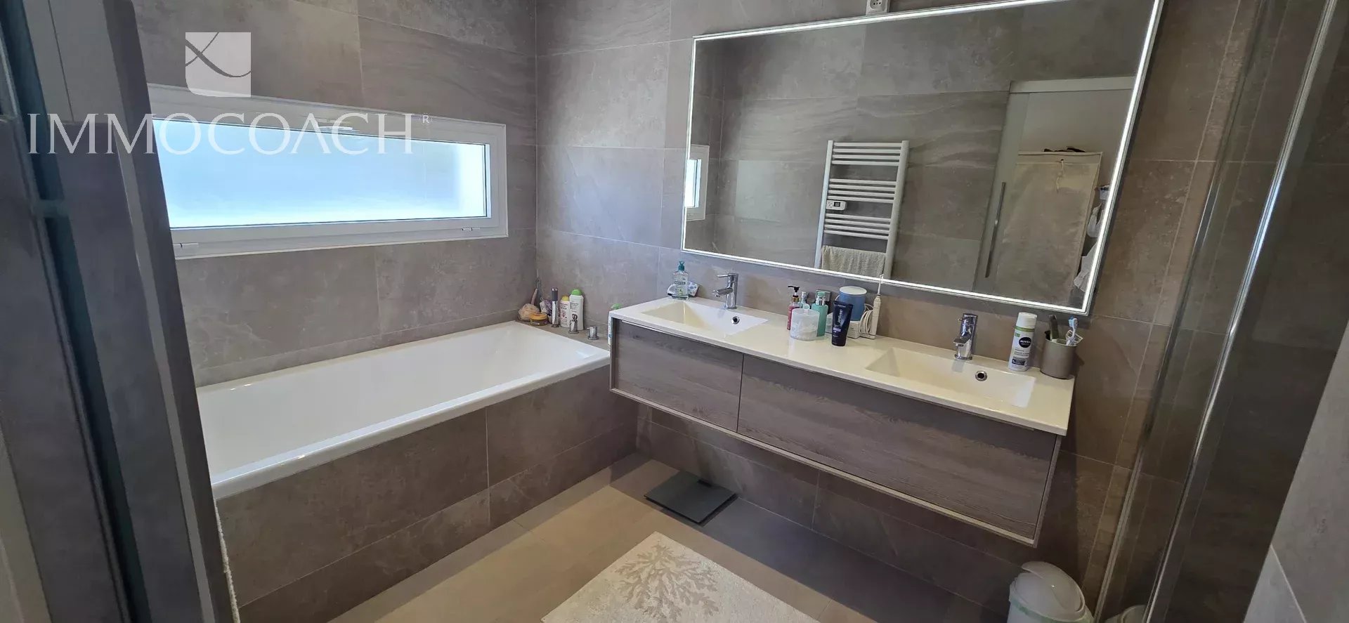 Salle de bain moderne avec baignoire et double vasque.