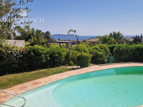 View of a villa with swimming pool and garden, offering a sea view in Carqueiranne.