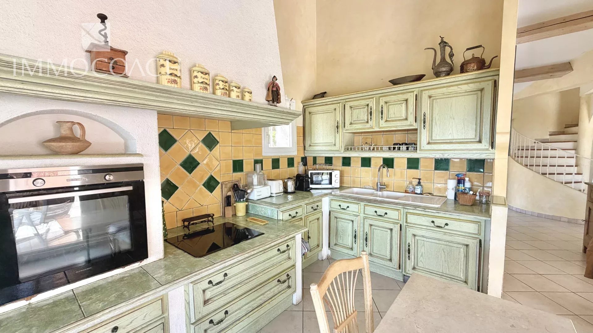 Villa kitchen in Carqueiranne Kitchen of a villa in Carqueiranne with green wood furniture and yellow and green tiles.