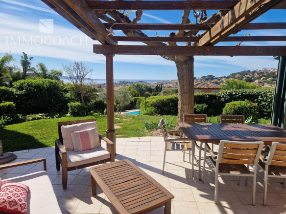 Terrace of a villa in Carqueiranne with sea view and well-maintained garden.