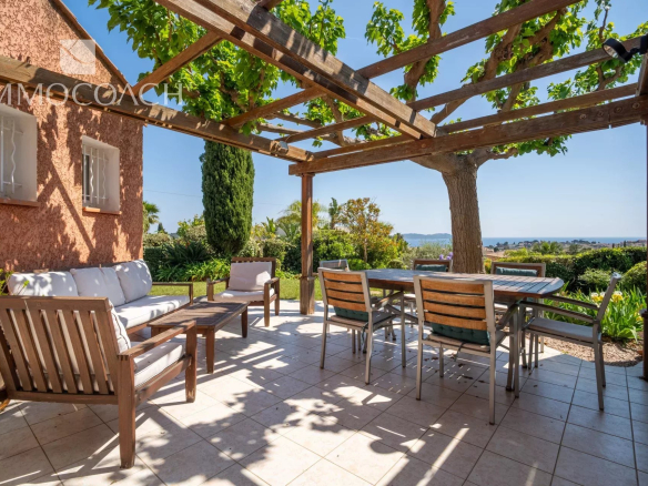 Wooden terrace with garden furniture and sea view in Carqueiranne.