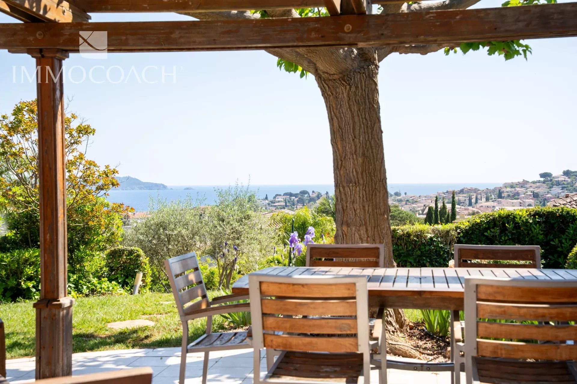 Villa with sea view in Carqueiranne Wooden terrace with table and chairs, overlooking the sea and the garden in Carqueiranne.