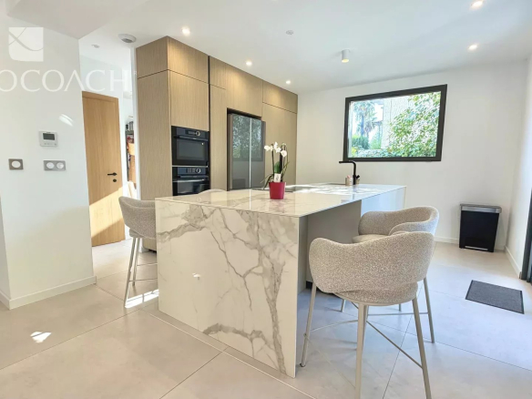 Cuisine moderne et lumineuse d'une maison rénovée à Hyères, avec îlot central et équipements haut de gamme.