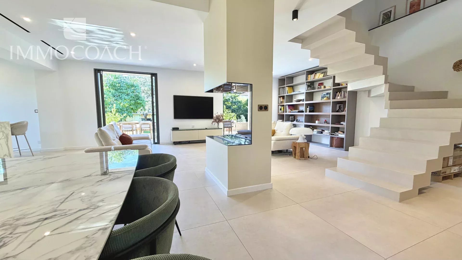 Intérieur d’une maison rénovée à Hyères Intérieur d'une maison moderne avec un séjour lumineux, cuisine américaine et escalier design.